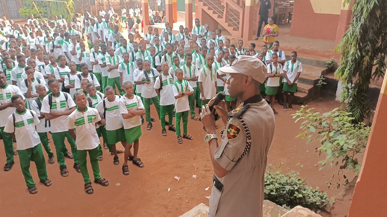 CHAPOL officer addressing students in green uniforms
