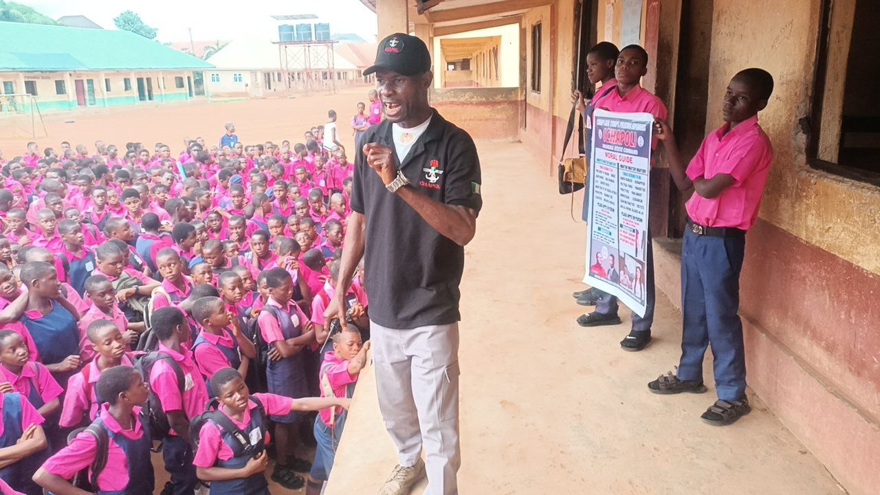 CHAPOL officer addressing students with Moral Guide banner